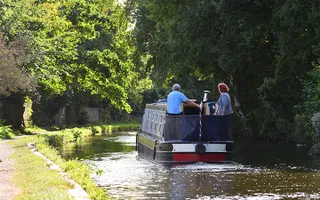 Couple driving a boat on the Coventry Canal