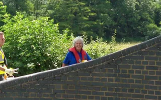 Volunteer walks over a canal bridge