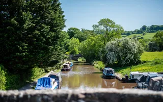 Looking down at moored boats on a rural section of the Monmouthshire & Brecon Canal