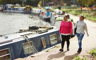 Two women walking along the canal