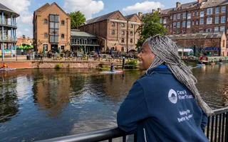 A woman standing by the water smiling