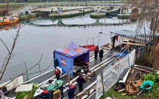 Wide above shot of site including purple tent next to water