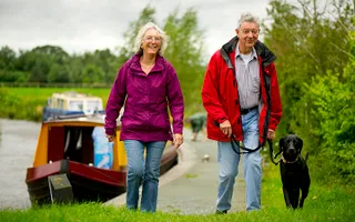 Two people walking with a dog on the Montgomery Canal