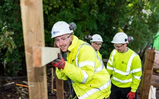 Young people in high vis and hard hats putting timber in place along towpath walkway