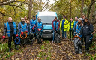 Group of people with litter pickers facing towards camera.
