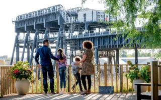 family standing on a platfrom over looking a view of a large metal structure