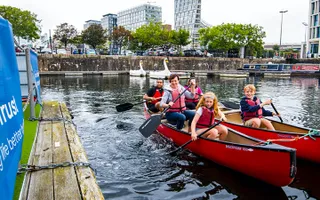 A group of people paddling canoes