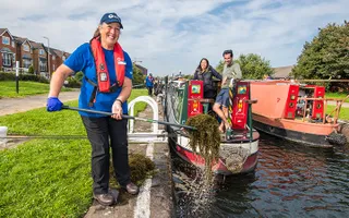 Volunteers picking weeds out of a lock at Bootle, Merseyside