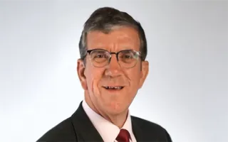 Man in black suit posing for a headshot