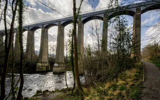 Looking up at an impressively large aqueduct, carrying the canal high over a flowing river.