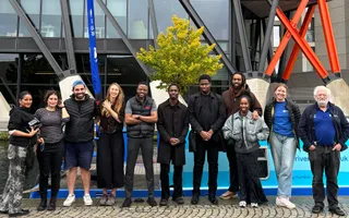 Workshop participants stand in a line beside barge in Paddington