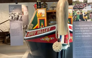 a colourful canal boat inside with other canal boat heritage objects