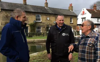 Two Licence Support Officers talk to a customer in front of a canal lock