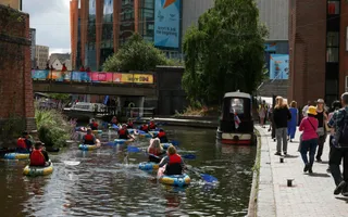 Group of paddlers on busy stretch of Birmingham & Fazeley Canal in summer