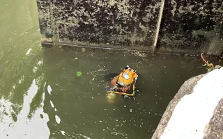 Diver floating in a canal next to a lock gate