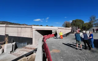 Wide shot of a constructon site of a bridge and people to the right