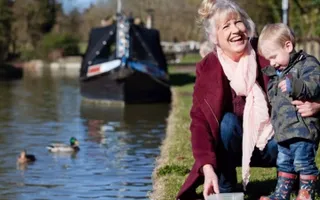 An adult and child feeding the ducks
