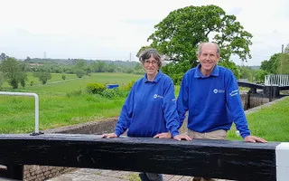 Volunteers lean on lock gate