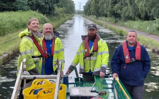Group of people standing on a boat wearing high vis and lifejackets