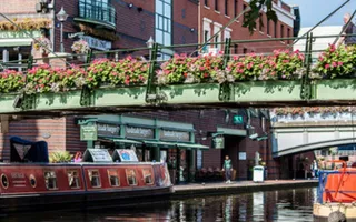 A bridge over a canal in central Birmingham is decorated with flowers.