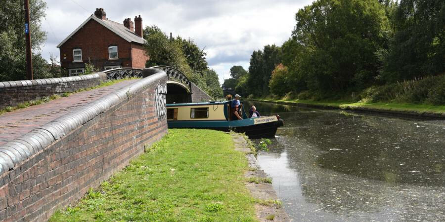 A canal boat sailing under a bridge on a Birmingham canal