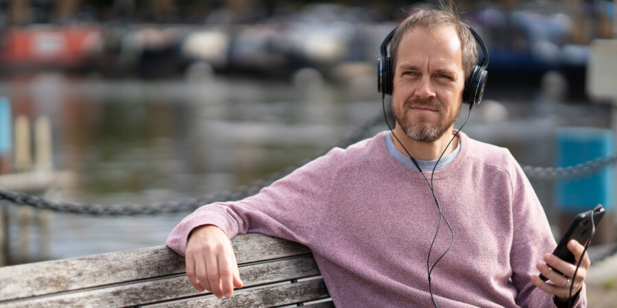 Man wearing headphones sitting on a bench