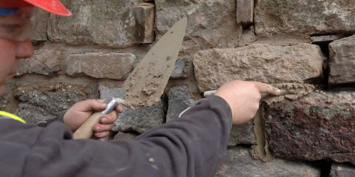 An engineer repointing a wall