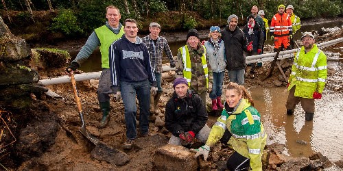 Volunteers by a flood-damaged canal