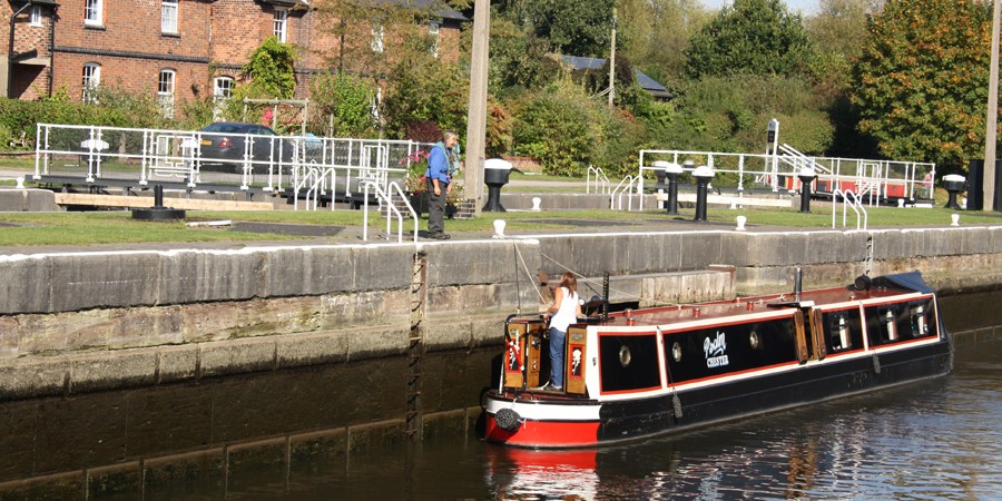 Lady on moored narrowboat talking to volunteer on bank