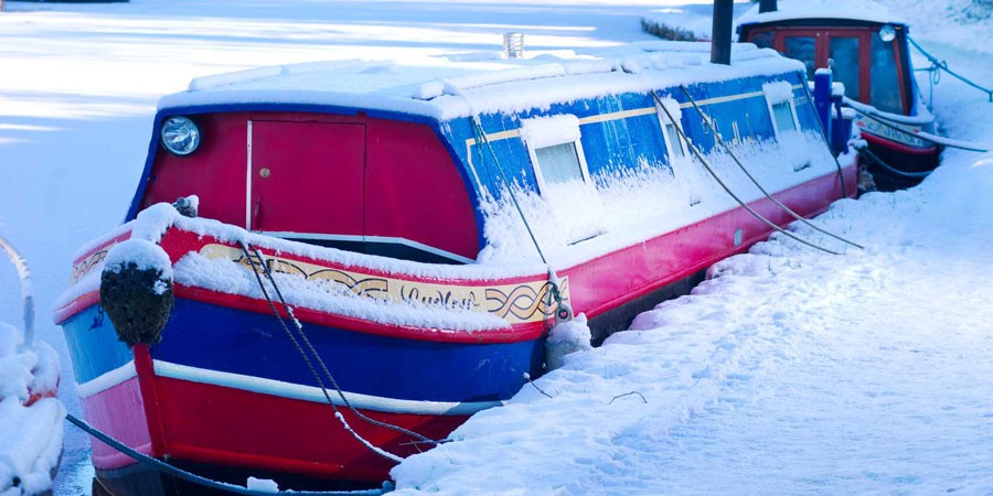 A boat moored in the snow on the Leeds & Liverpool Canal