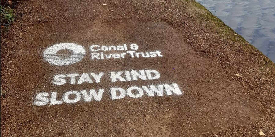 Stay kind slow down message on towpath