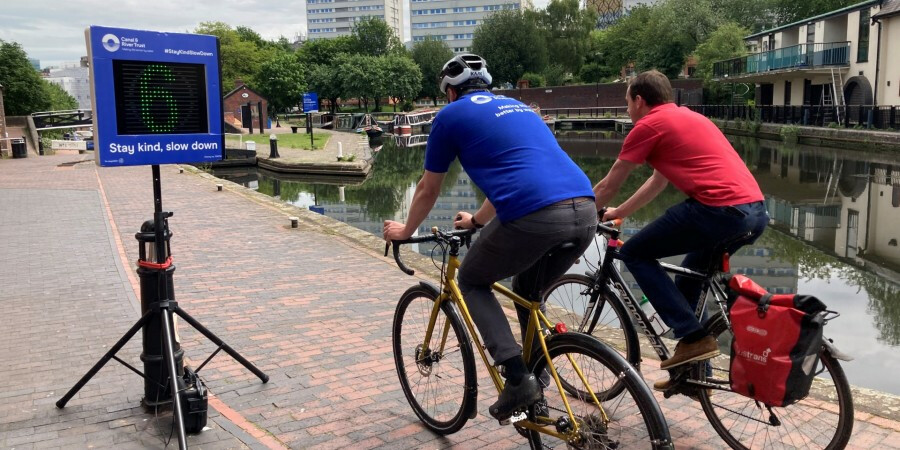 Two men riding bikes on the canal