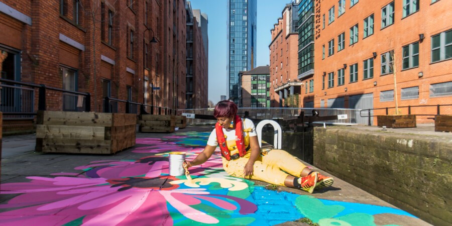 Woman painting mural on towpath floor