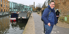 Man smiling and walking down the canal