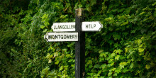 Signposts in a rural setting, one saying 'HELP'