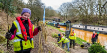 Group of young people on the canal planting trees