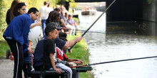 Young children learning to fish buy the canal