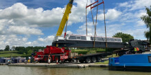 Crane lifting a boat above the canal